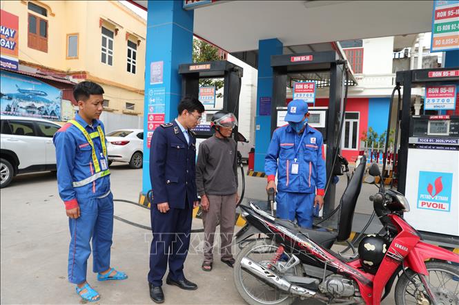 Cán bộ Đội Quản lý thị trường số 6, Chi cục QLTT Thanh Hóa có mặt tại cửa hàng xăng dầu để nắm bắt tình hình cung ứng, ổn định thị trường khi giá xăng biến động. Ảnh: Khiếu Tư - TTXVN