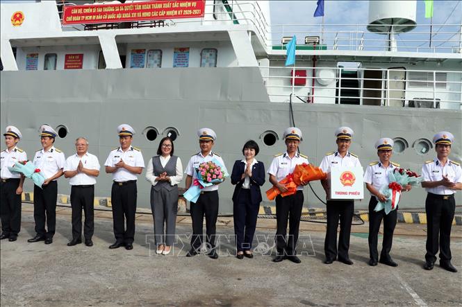 Thành viên Ủy ban Bầu cử xã Long Sơn (Thành phố Hồ Chí Minh) và Thủ trưởng Vùng 2 Hải quân tặng hoa chúc mừng Tổ bầu cử sớm trên biển. Ảnh: Đoàn Mạnh Dương-TTXVN