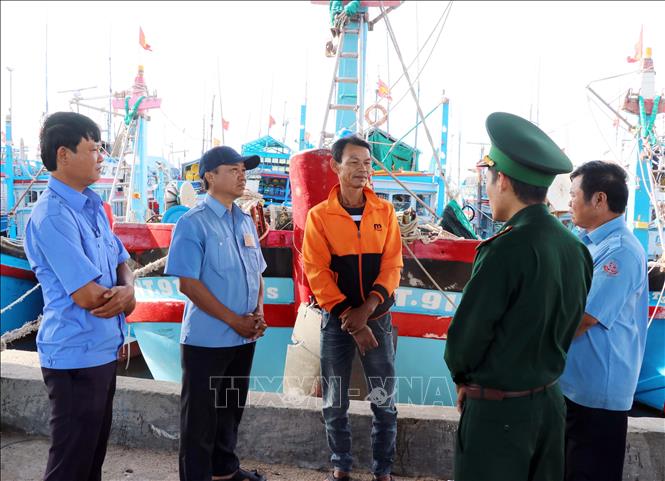 Lực lượng Trạm kiểm soát Biên phòng Cà Ná và Ban quản lý Cảng cá Cà Ná tuyên truyền cho ngư dân về quy định IUU. Ảnh: Công Thử - TTXVN