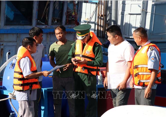 Lực lượng Trạm kiểm soát Biên phòng Cà Ná và Ban quản lý Cảng cá Cà Ná kiểm tra giấy tờ liên quan đến tàu thuyền của ngư dân. Ảnh: Công Thử - TTXVN