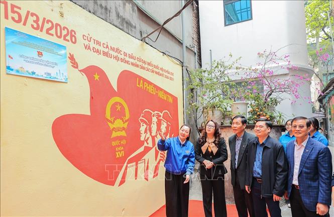 Đ/c Phạm Thu Phương, Đảng uỷ viên, Phó Chủ tịch UB MTTQ VN phường, Bí thư Đoàn phường Ba Đình giới thiệu công trình dân vận khéo “Tranh tường bích họa” chào mừng bầu cử đại biểu Quốc hội và đại biểu HĐND các cấp nhiệm kỳ 2026 - 2031 đến các đại biểu tham dự buổi Lễ. Ảnh: Lê Đông - TTXVN