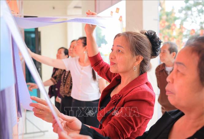 Nguời dân tìm hiểu thông tin các ứng viên tại đơn vị bầu cử số 6, khu vực bỏ phiếu số 29. Ảnh: Hoàng Hiếu - TTXVN