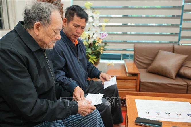 Nhân viên tổ bầu cử đưa thẻ cử tri đến hộ gia đình ông Nguyễn Trí Tuy, cụm dân cư số 3, thôn Hạ Mỗ, xã ô Diên. Ảnh: Hoàng Hiếu - TTXVN