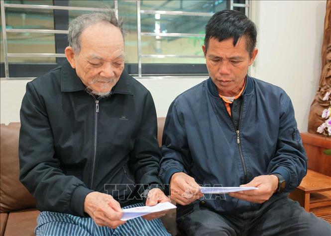 Nhân viên tổ bầu cử đưa thẻ cử tri đến hộ gia đình ông Nguyễn Trí Tuy, cụm dân cư số 3, thôn Hạ Mỗ, xã ô Diên. Ảnh: Hoàng Hiếu - TTXVN