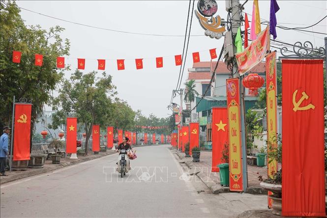 Tuyến đường xã Ô Diên rực rỡ cờ Đảng, cờ tổ quốc, trang hoàng chào mừng. Ảnh: Hoàng Hiếu - TTXVN