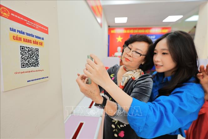 Tại các điểm triển khai, Đoàn viên thanh niên đồng thời hướng dẫn cán bộ cơ sở và người dân quét mã QR, truy cập và sử dụng “Cẩm nang bầu cử” trên điện thoại thông minh. Ảnh: Lê Đông - TTXVN