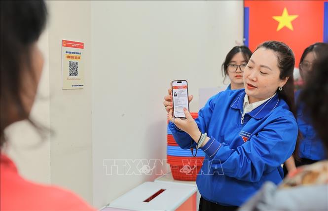Tại các điểm triển khai, Đoàn viên thanh niên đồng thời hướng dẫn cán bộ cơ sở và người dân quét mã QR, truy cập và sử dụng “Cẩm nang bầu cử” trên điện thoại thông minh. Ảnh: Lê Đông - TTXVN