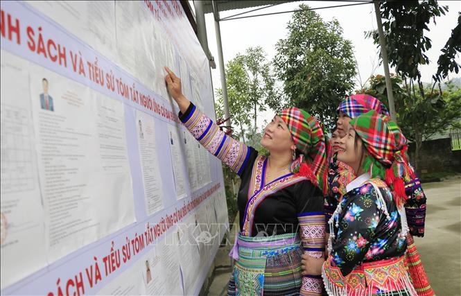 Đồng bào dân tộc Mông ở thôn Đồng Ruộng, xã Quy Mông đến hội trường thôn xem danh sách niêm yết cử tri và những đại biểu ứng cử. Ảnh: Đinh Thùy - TTXVN