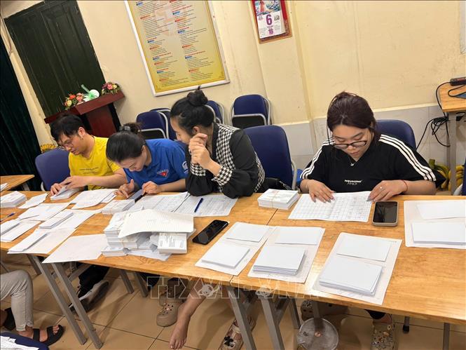 Các tình nguyện viên giúp tổ bầu cử sắp xếp, phân loại thẻ cử tri. Ảnh: Minh Ánh/TTXVN phát