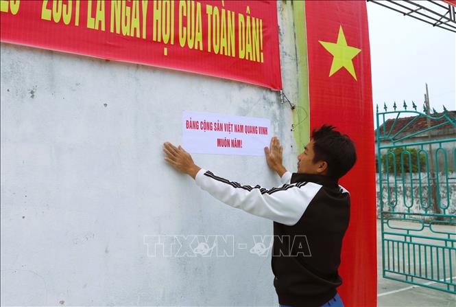 Công tác trang trí khánh tiết, tuyên truyền về Ngày bầu cử tại điểm bỏ phiếu làng biển xóm Quyết Thắng (xã Diễn Châu, tỉnh Nghệ An) được gấp rút hoàn thành. Ảnh: Xuân Tiến – TTXVN 