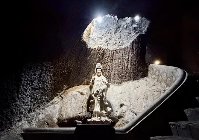 A statue of Avalokiteshvara Bodhisattva is placed on the rock wall inside the cave under Hang Pagoda. VNA Photo: Thanh Sang