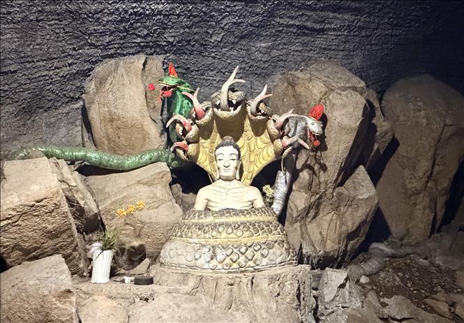 Spaces between stones in the cave under Hang Pagoda are adorned with Buddha statues for worship. VNA Photo: Thanh Sang