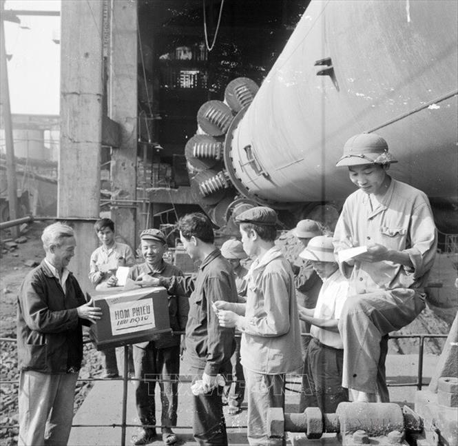 Trong điều kiện đất nước thống nhất, sự kiện lịch sử có ý nghĩa trọng đại là tổ chức thành công cuộc Tổng tuyển cử bầu Quốc hội chung của cả nước - Quốc hội khóa VI. Quốc hội đã quyết định những vấn đề quan trọng hàng đầu trong thời kỳ phát triển mới của dân tộc. Trong ảnh: Công nhân lò rung số 6 và 7, Nhà máy Xi măng Hải Phòng bỏ phiếu bầu đại biểu Quốc hội khóa VI tại nơi làm việc. Ảnh: TTXVN