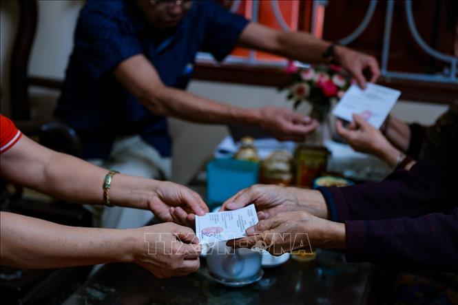 Thành viên tổ bầu cử số 5, phường Vĩnh Hưng phát thẻ cử tri đến từng hộ trên địa bàn. Ảnh: Phạm Tuấn Anh - TTXVN