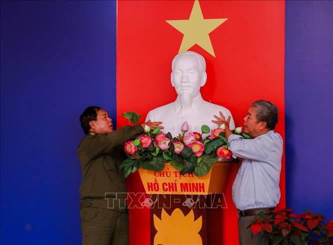 Tỉ mẩn chuẩn bị từng chi tiết nhỏ tại khu vực bỏ phiếu. Các thành viên tổ bầu cử phường Vĩnh Hưng đang hoàn tất khâu trang trí trang trọng khu vực khánh tiết, sẵn sàng cho ngày hội lớn. Ảnh: Quỳnh Anh - TTXVN phát