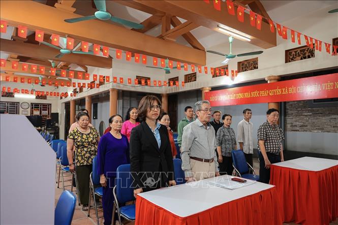 Các thành viên trong tổ bầu cử của khu vực bỏ phiếu số 17 diễn tập chào cờ chuẩn bị cho ngày bầu cử. Ảnh: Phạm Tuấn Anh - TTXVN