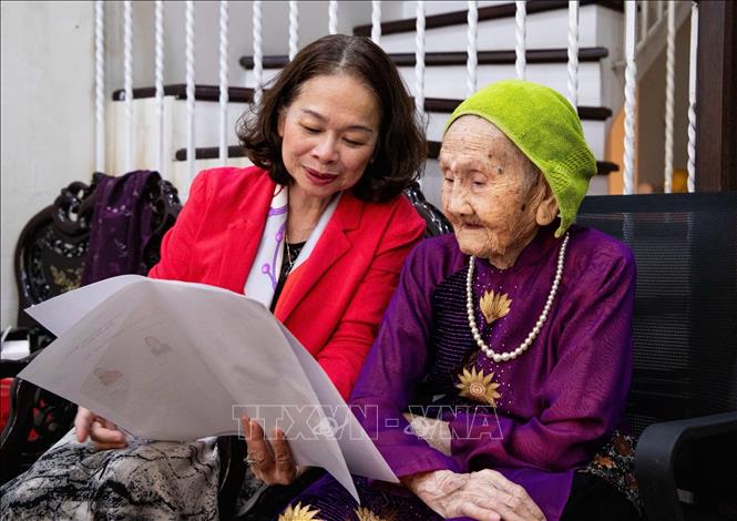 Cán bộ phường Hồng Hà trực tiếp hỗ trợ, phổ biến danh sách người ứng cử cho Mẹ Việt Nam Anh hùng Nguyễn Thị Tẹo (99 tuổi). Ảnh: Vân Chi/TTXVN phát

