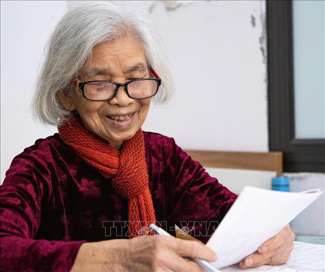 Bà Vũ Thị Tuyết, (95 tuổi), đảng viên 75 năm tuổi Đảng nghiên cứu, ghi chép thông tin các ứng cử viên, với tiêu chí lựa chọn những người có đủ trình độ, năng lực và đạo đức. Ảnh: Vân Chi/TTXVN phát
