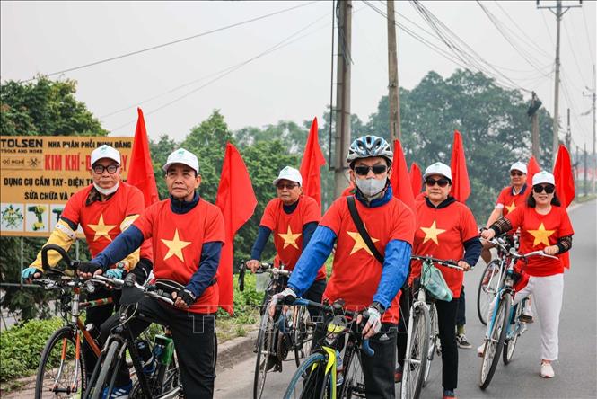 Các thành viên tuyên truyền lưu động xã Ô Diên với đông phục, cờ đỏ cổ động cho ngày bầu cử. Ảnh: Hoàng Hiếu - TTXVN 