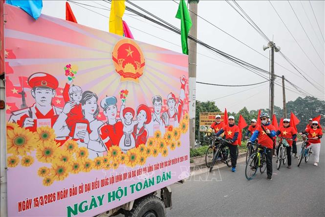 Đoàn tuyên truyền lưu động xã Ô Diên với đông phục, cờ đỏ cổ động cho ngày bầu cử. Ảnh: Hoàng Hiếu - TTXVN 