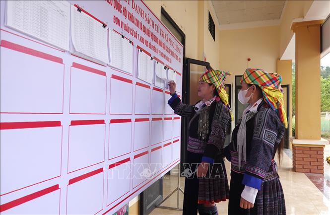 Cử tri xã Púng Luông xem danh sách cử tri được niêm yết công khai tại khu vực bỏ phiếu. Ảnh: Tuấn Anh - TTXVN