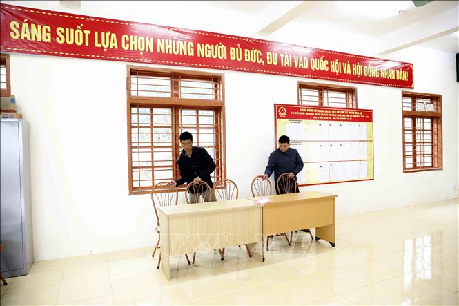 Thành viên Tổ bầu cử kê lại bàn ghế sẵn sàng cho ngày bầu cử tại khu vực bỏ phiếu số 02, đơn vị bầu cử số 01, bản Thống Nhất, xã Mường Sại (Sơn La). Ảnh: Quang Quyết - TTXVN