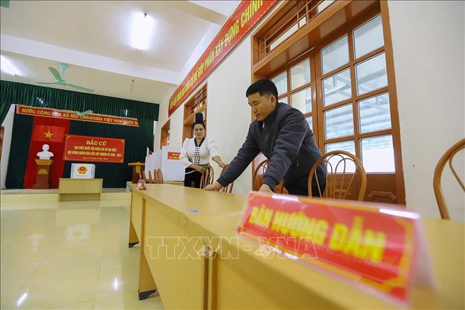 Thành viên Tổ bầu cử kê lại bàn ghế sẵn sàng cho ngày bầu cử tại khu vực bỏ phiếu số 02, đơn vị bầu cử số 01, bản Thống Nhất, xã Mường Sại (Sơn La). Ảnh: Trọng Đạt - TTXVN