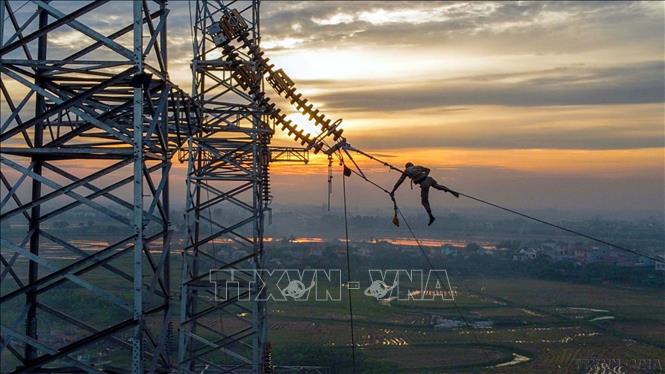 Nhiếp ảnh Việt Nam tạo ra nhiều tác phẩm góp phần tích cực trong việc thực hiện thành công sự nghiệp công nghiệp hóa, hiện đại hóa đất nước. Trong ảnh: Công nhân thi công trên công trình đường dây 500 kV mạch 3 Quảng Trạch – Phố Nối. Ảnh: Huy Hùng - TTXVN