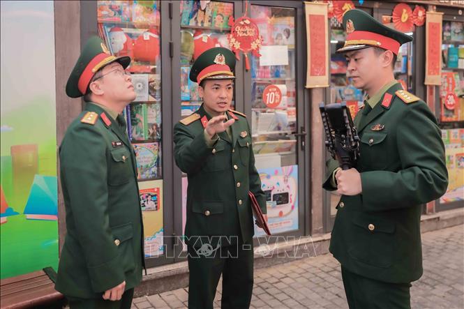 Thiếu tá Trần Quang Trung, Phó Chỉ huy trưởng Ban Chỉ huy Quân sự phường Cửa Nam trực tiếp chỉ đạo lực lượng an ninh sử dụng súng CAV-14, chế áp phương tiện bay không người lái, bảo đảm an toàn tuyệt đối khu vực bầu cử. Ảnh: Phan Phương – TTXVN