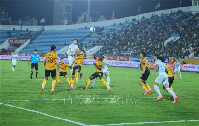 Tình huống tranh chấp bóng giữa các cầu thủ Thép Xanh Nam Định (áo trắng) và các cầu thủ Đông Á Thanh Hóa. Ảnh: Công Luật - TTXVN