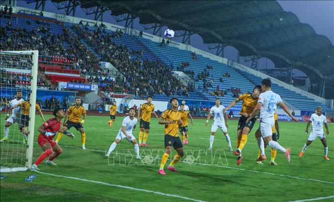 Tình huống tranh chấp bóng giữa các cầu thủ Thép Xanh Nam Định (áo trắng) và các cầu thủ Đông Á Thanh Hóa. Ảnh: Công Luật - TTXVN