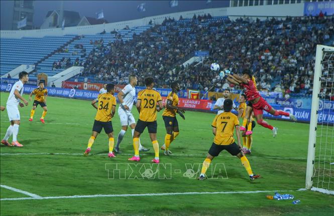 Tình huống tranh chấp bóng giữa các cầu thủ Thép Xanh Nam Định (áo trắng) và các cầu thủ Đông Á Thanh Hóa. Ảnh: Công Luật - TTXVN