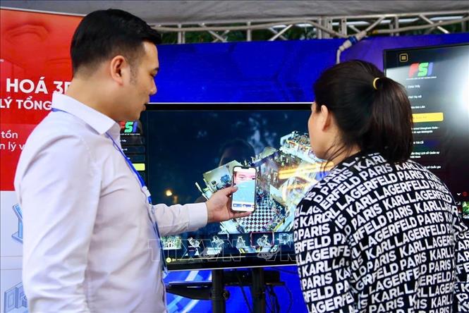 Nhân viên gian hàng hướng dẫn du khách thao tác thiết bị VR nhằm trải nghiệm mô phỏng hành trình khám phá các điểm du lịch. Ảnh: Lan Anh/TTXVN phát