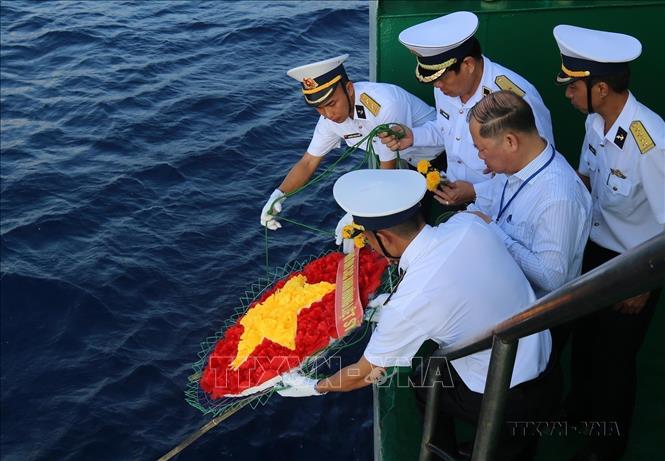 Chuẩn đô đốc Phan Tuấn Hùng, Phó Tư lệnh Quân chủng Hải quân cùng cán bộ, chiến sỹ thả vòng hoa hình cờ Tổ quốc xuống biển, tưởng niệm các liệt sỹ đã hi sinh trên vùng biển Trường Sa (4/6/2021). Ảnh: Sỹ Tuyên - TTXVN