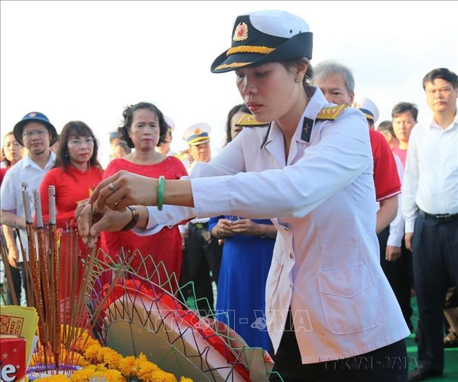 Thượng úy Hải quân Trần Thị Thủy (con gái liệt sỹ, Anh hùng LLVT Trần Văn Phương hy sinh ngày 14/3/1988 tại Gạc Ma) xúc động thắp hương tưởng niệm các liệt sỹ hy sinh trên vùng biển Trường Sa (4/6/2021). Ảnh: Sỹ Tuyên - TTXVN