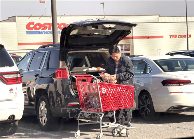 Người dân xếp hàng lên xe sau khi mua sắm tại một khu trung tâm thương mại ở bang Maryland (Mỹ). Ảnh: Ngọc Quang- PV TTXVN tại Mỹ