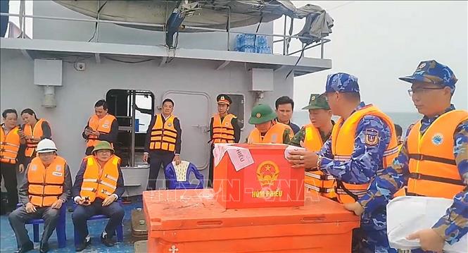Ban chỉ đạo công tác bầu cử đặc khu Bạch Long Vĩ di chuyển hòm phiếu phụ ra tàu nơi lực lượng chấp pháp đang làm nhiệm vụ trên biển để cử tri bỏ phiếu. Ảnh: TTXVN phát