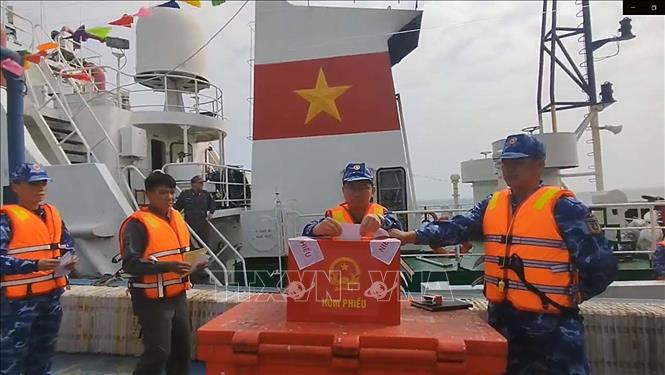 Ban chỉ đạo công tác bầu cử đặc khu Bạch Long Vĩ di chuyển hòm phiếu phụ ra tàu nơi lực lượng chấp pháp đang làm nhiệm vụ trên biển để cử tri bỏ phiếu. Ảnh: TTXVN phát