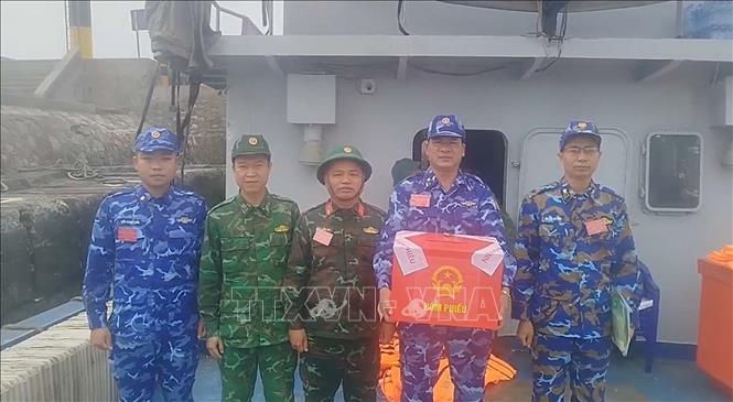Ban chỉ đạo công tác bầu cử đặc khu Bạch Long Vĩ di chuyển hòm phiếu phụ ra tàu nơi lực lượng chấp pháp đang làm nhiệm vụ trên biển để cử tri bỏ phiếu. Ảnh: TTXVN phát