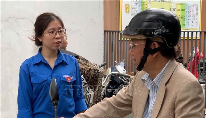 Thanh niên tình nguyện hướng dẫn cử tri đến tìm hiểu thông tin tại các khu vực bỏ phiếu. Ảnh: Kim Anh – TTXVN