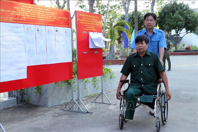 Nhân viên Trung tâm hỗ trợ cử tri Nguyễn Văn Thắng, thương binh hạng 1/4 tại tham gia bầu cử. Ảnh: Đoàn Mạnh Dương-TTXVN