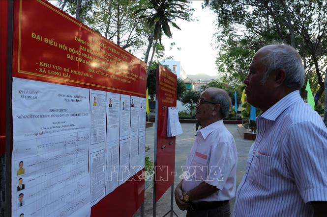 Cử tri nghiên cứu về các ứng cử viên. Ảnh: Đoàn Mạnh Dương-TTXVN