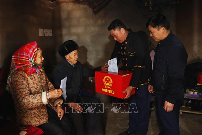 Tổ công tác mang hòm phiếu di động đến nhà cho cử tri là người già và người khuyết tật thực hiện quyền bầu cử. Ảnh: Minh Đức – TTXVN