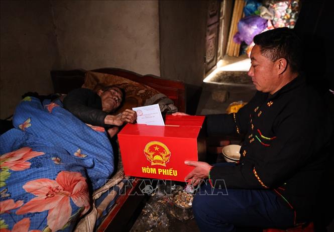 Tổ công tác mang hòm phiếu di động đến nhà cho cử tri là người già và người khuyết tật thực hiện quyền bầu cử. Ảnh: Minh Đức – TTXVN