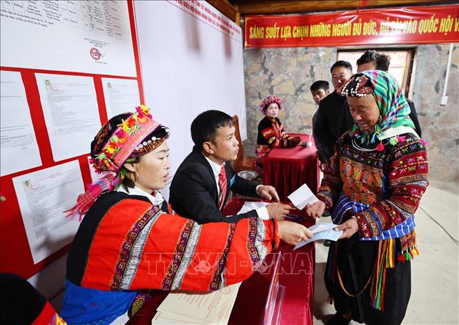 Tại bàn phát phiếu, tổ bầu cử đưa thẻ cử tri để nhận phiếu bầu cử. Ảnh: Minh Đức – TTXVN