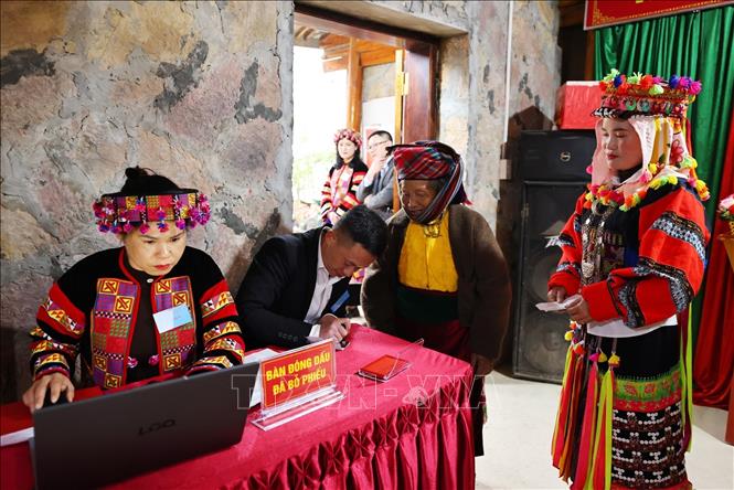 Đóng dấu đã bỏ phiếu cho các cử tri hoàn thành công tác bầu cử. Ảnh: Minh Đức – TTXVN