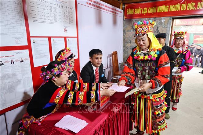 Tại bàn phát phiếu, tổ bầu cử đưa thẻ cử tri để nhận phiếu bầu cử. Ảnh: Minh Đức – TTXVN