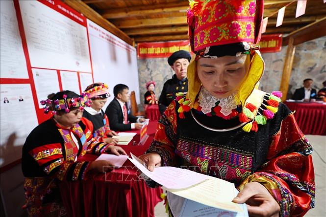 Các cử tri kiểm tra phiếu bầu trước khi cho vào hòm phiếu. Ảnh: Minh Đức – TTXVN