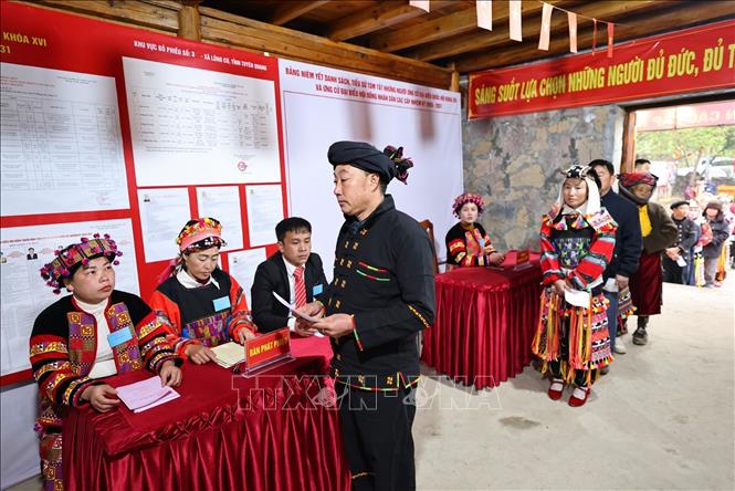 Tại bàn phát phiếu, tổ bầu cử đưa thẻ cử tri để nhận phiếu bầu cử. Ảnh: Minh Đức – TTXVN