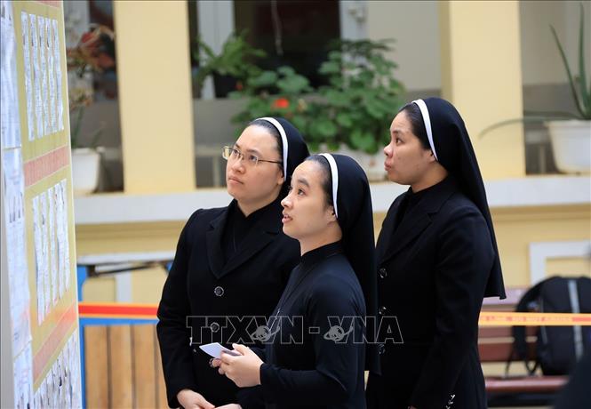 Các nữ tu dòng Mến Thánh Giá 31 Nhà Chung xem danh sách những người ứng cử tại khu vực bỏ phiếu số 1, phường Hoàn Kiếm. Ảnh: Tuấn Anh - TTXVN